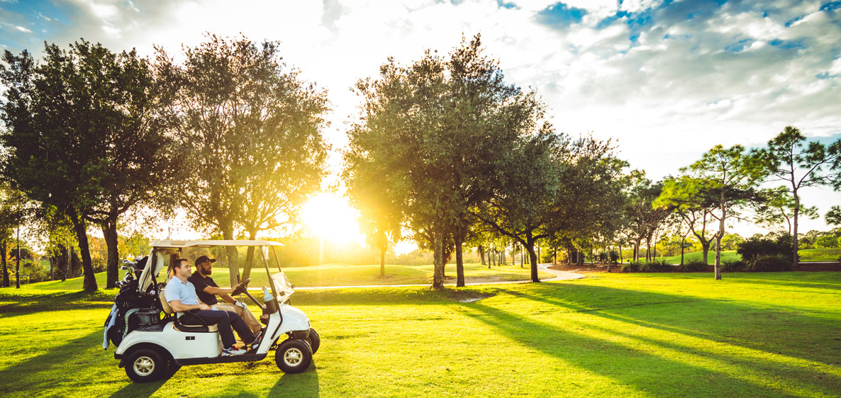 Men driving a golf cart powered by a lithium-ion battery.