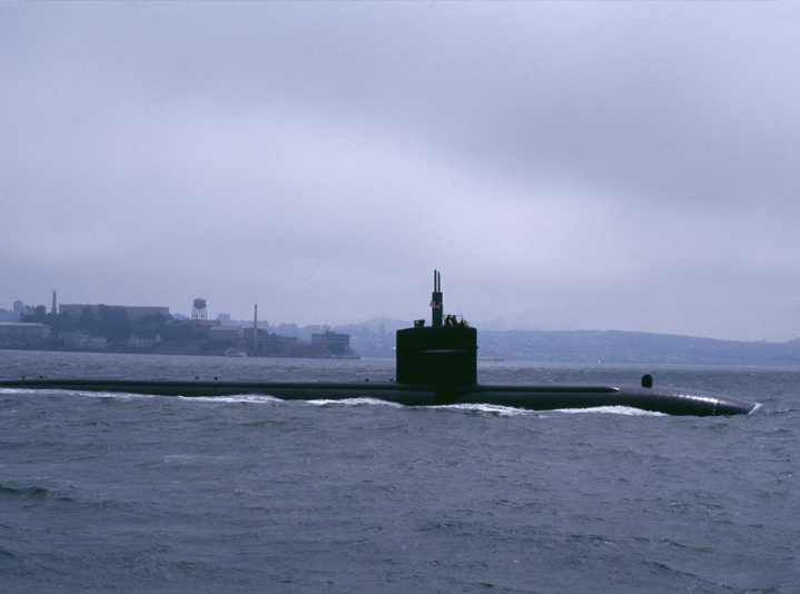 U.S. military submarine submerging in the water.