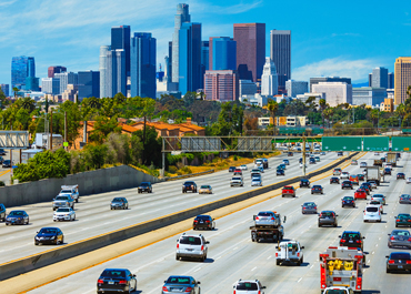 Traffic powered by lead and lithium batteries with cityscape in the background.