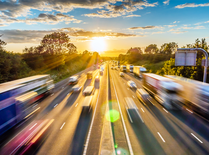 Blurred view of traffic on a highway at sunset.