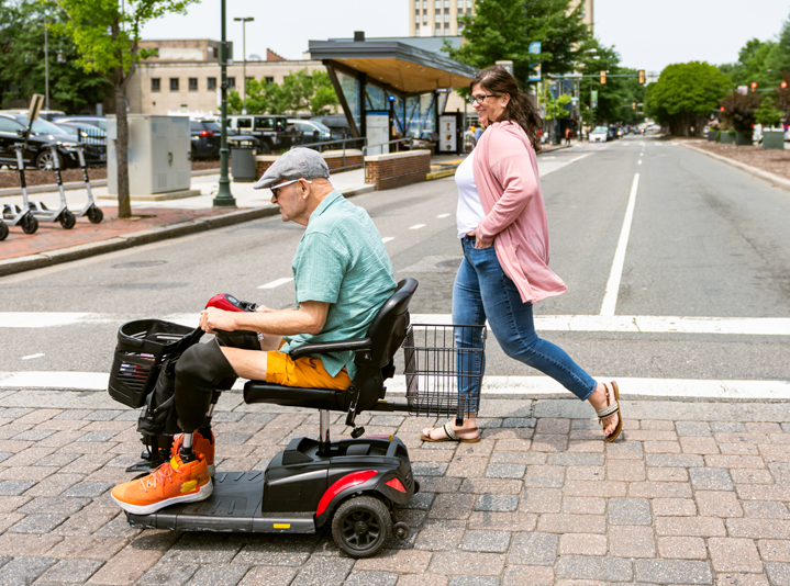 Man on a motorized scooter powered by batteries.