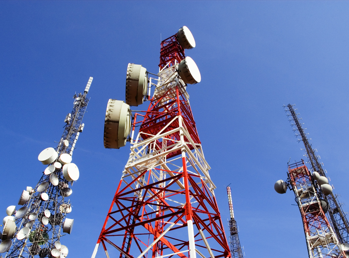 A low-angle view of multiple telecommunications towers.