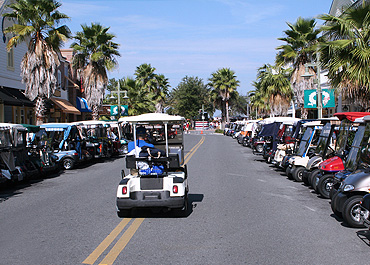 Golf carts parked on a busy shopping street